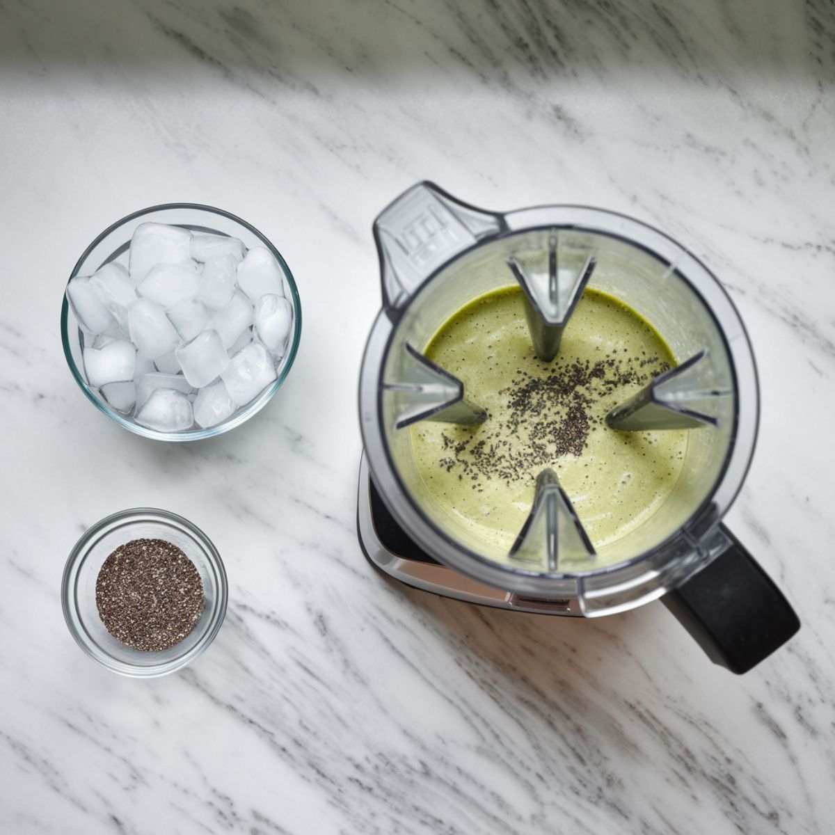 Chia seeds and ice being added to the blender, pulsing the mixture into a frosty, smooth consistency.