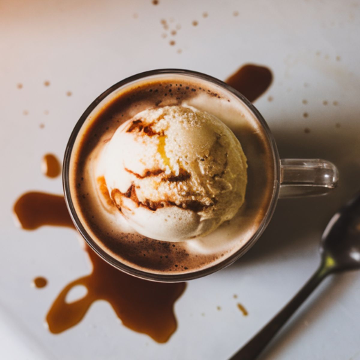 A freshly made Starbucks Affogato Coffee with vanilla ice cream melting under hot espresso, placed on a white kitchen counter.