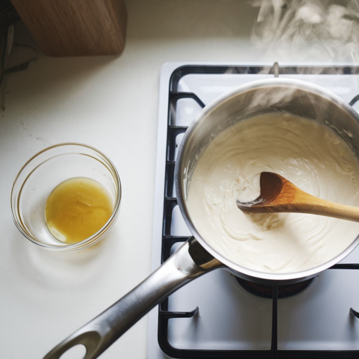 Heating cream and dissolving gelatin for the panna cotta base on a home kitchen stove.