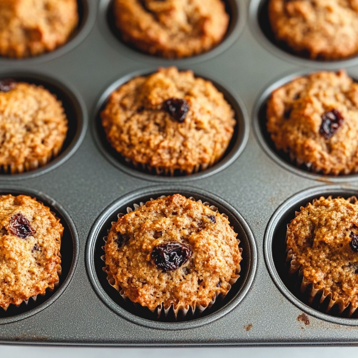 Raisin bran muffins fresh out of the oven in a muffin tin