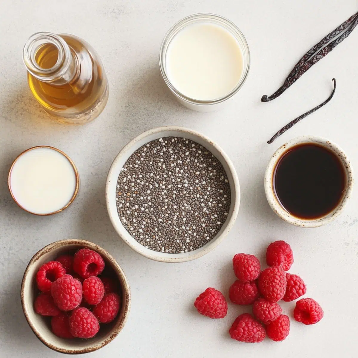 Ingredients for raspberry chia seed pudding displayed on a white countertop