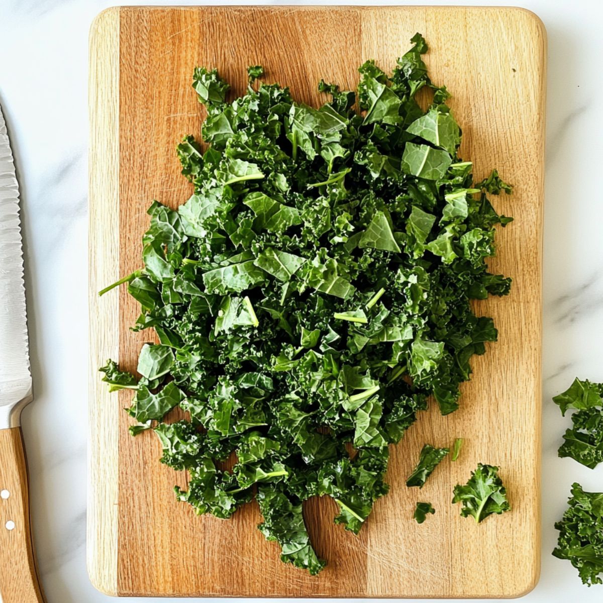 Chopping kale leaves on a wooden cutting board in a home kitchen