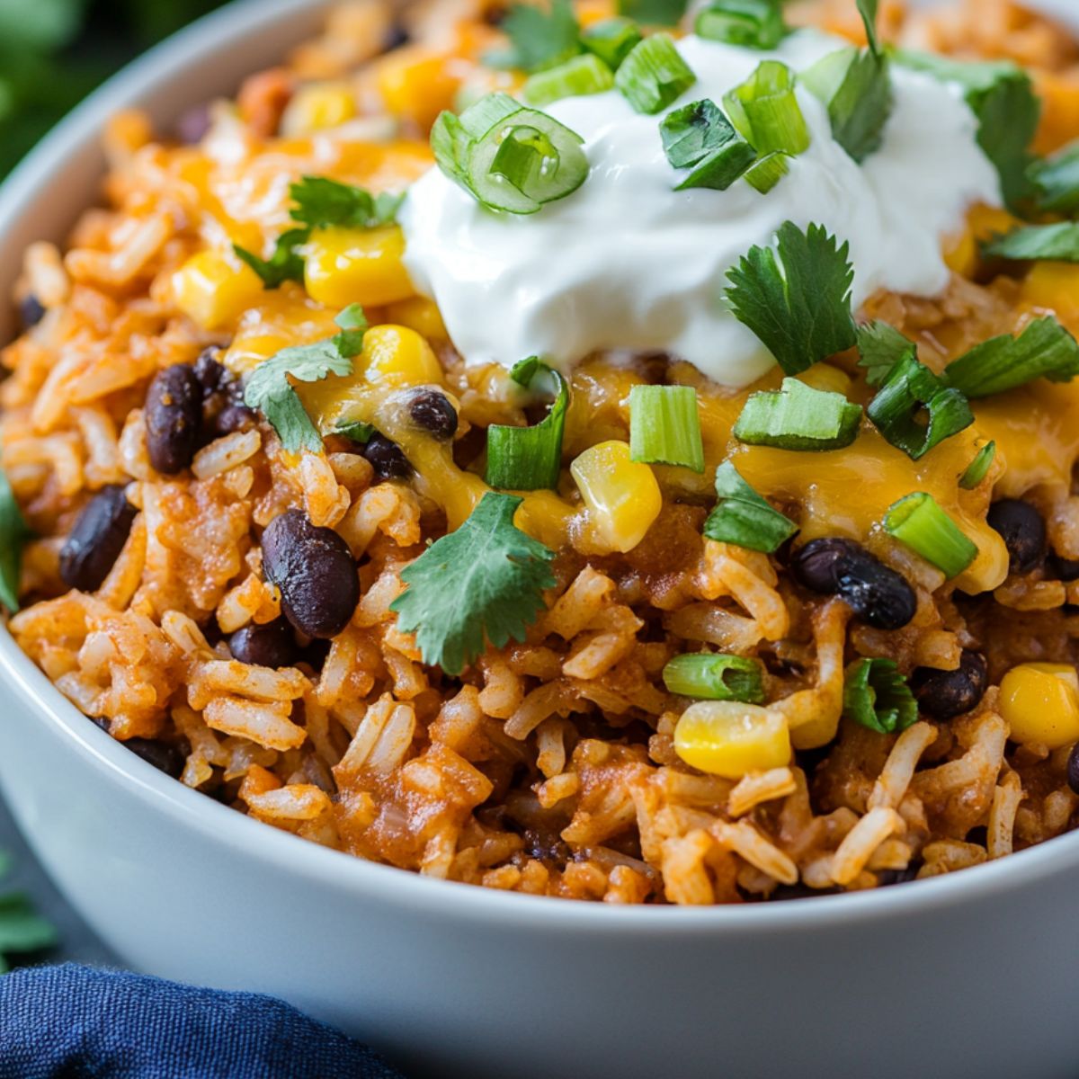 Homemade Cheesy Taco Rice in a skillet with cheese melted on top and garnished with cilantro