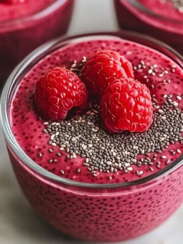 Raspberry chia seed pudding served in a small glass on a countertop