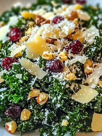Overhead shot of lemon garlic kale salad in a white bowl on a kitchen counter