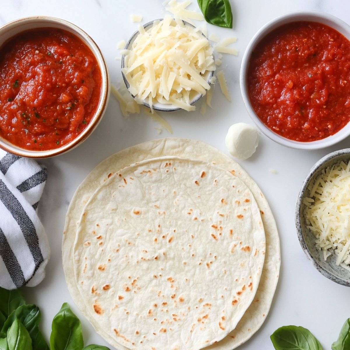 Ingredients for making air fryer tortilla pizza laid out on a kitchen counter