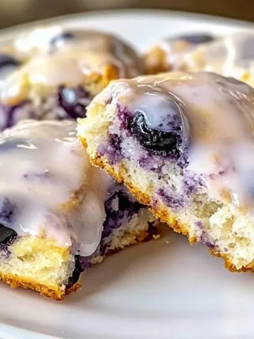 Freshly baked blueberry biscuits with lemon glaze, served on a white kitchen counter