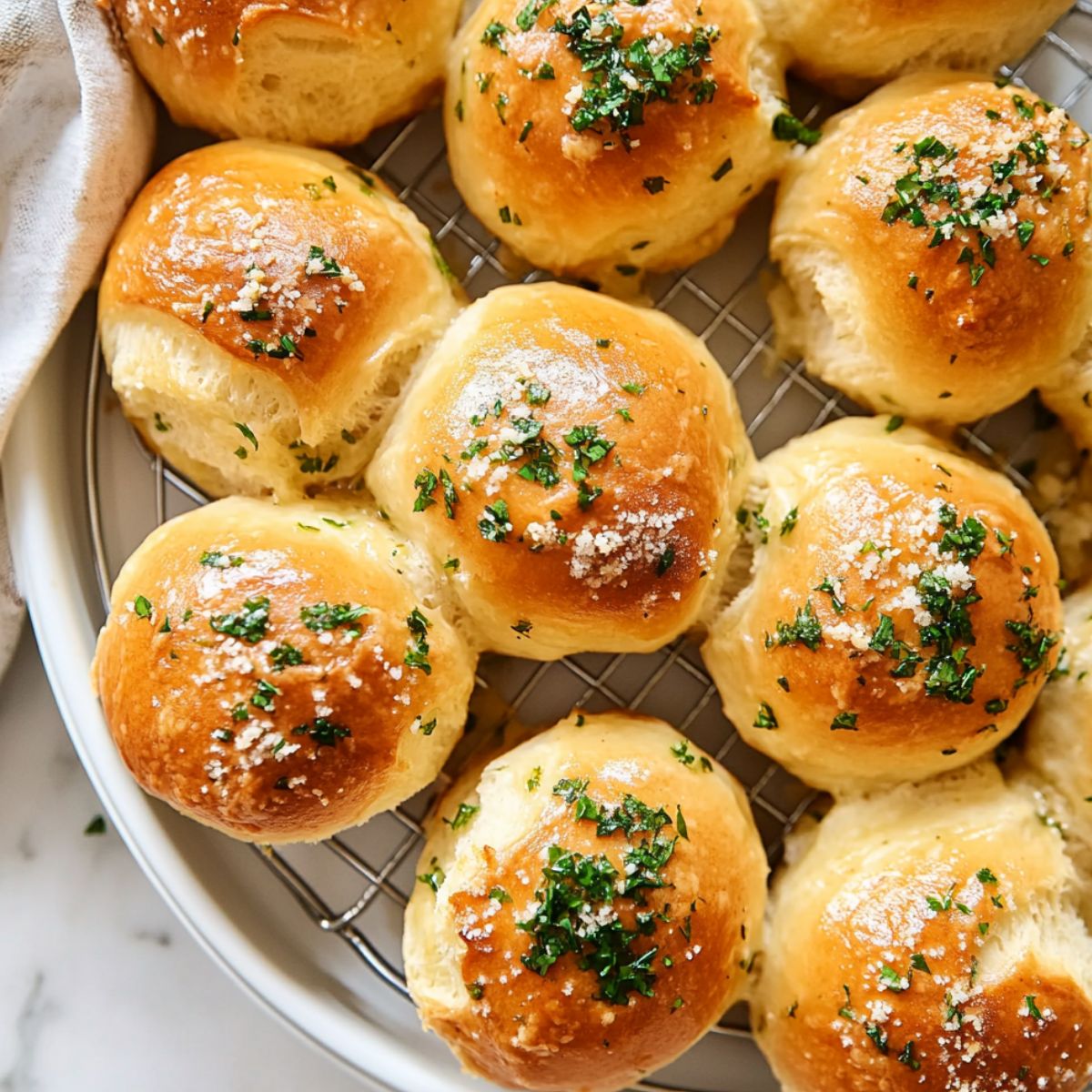 Garlic butter bread rolls cooling on a wire rack, ready to serve
