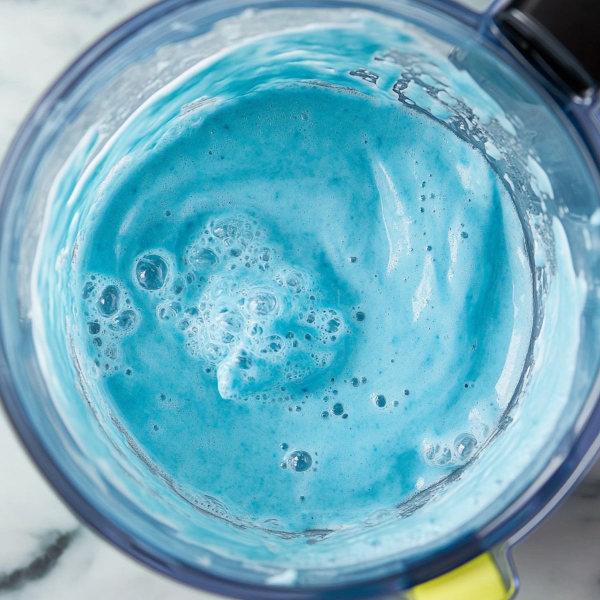 Blue syrup and crushed ice added to blender