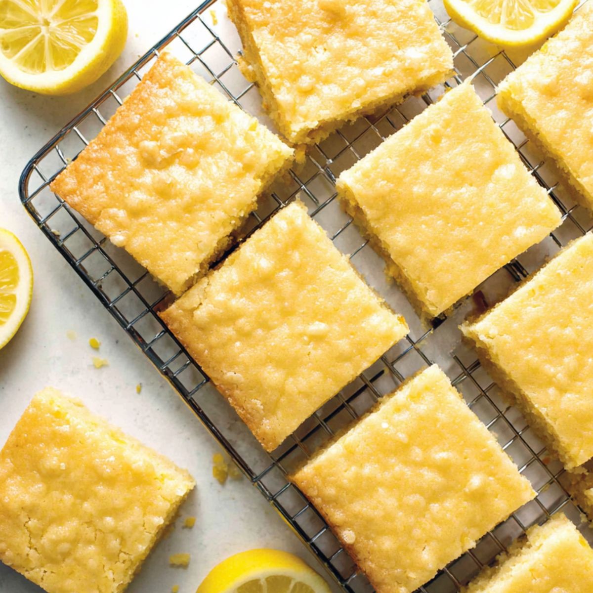 Fudgy lemon brownies cooling on counter with a few slices cut