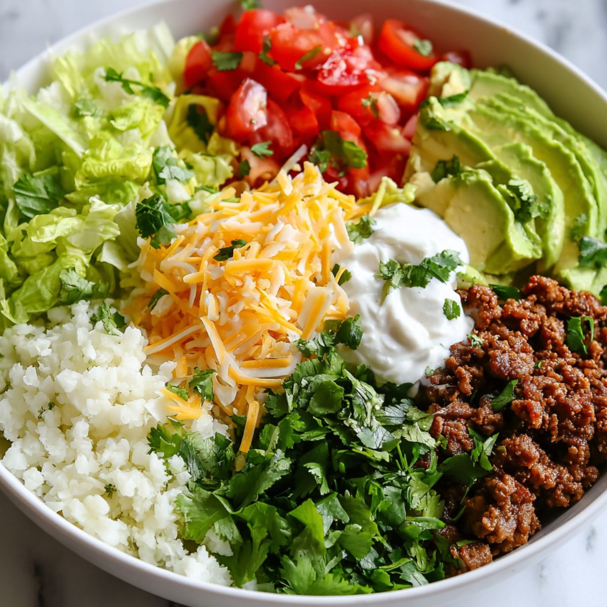 Assembling a low carb burrito bowl with fresh toppings