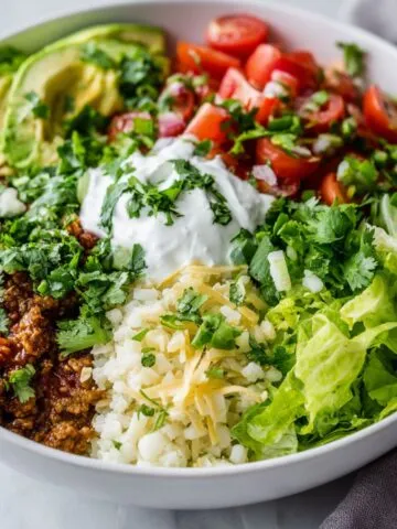 Low carb burrito bowl with fresh toppings on a white kitchen counter