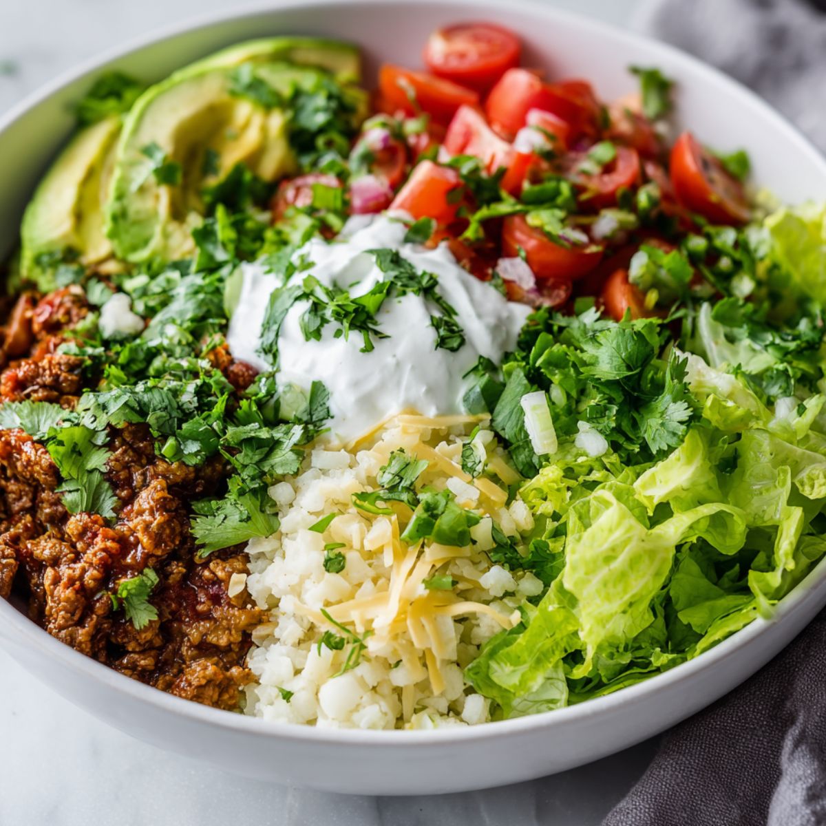  Low carb burrito bowl with fresh toppings on a white kitchen counter