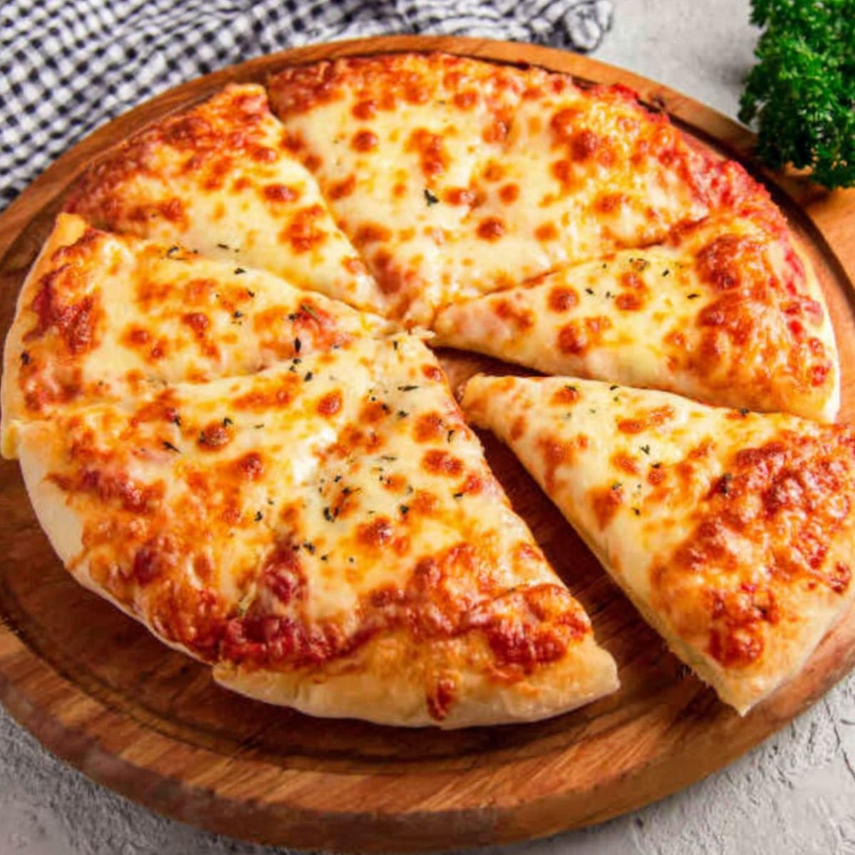  Homemade cheesy pizza with gooey cheese pull on a white kitchen counter