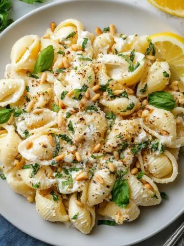 Homemade Creamy Lemon Feta Pasta in a white dinner plate on a kitchen counter