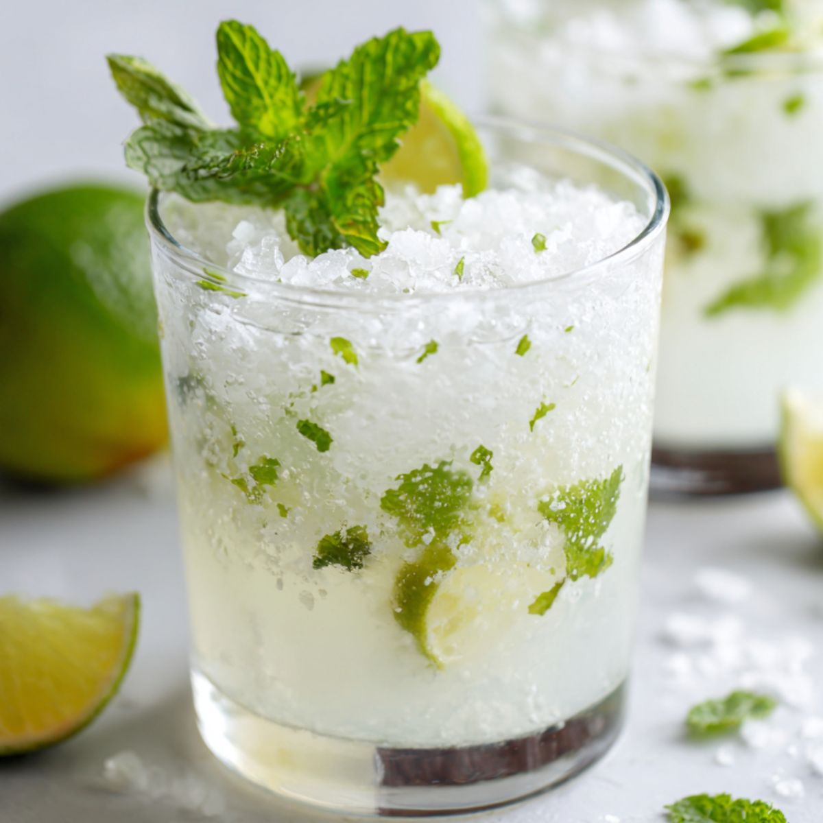 Finished coconut mojito with mint garnish on a white counter.