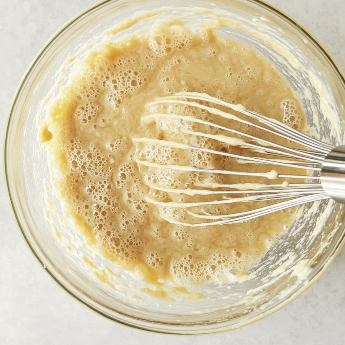 Mixing gluten free pancake batter with cast iron skillet preheating in the oven.