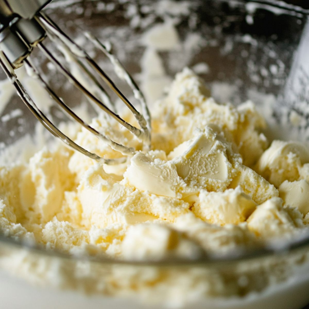 Butter and sugar being creamed together in a mixing bowl