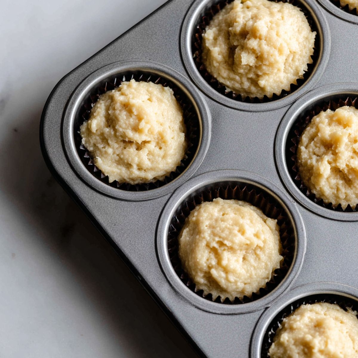 Mochi muffin batter scooped into muffin tin before baking