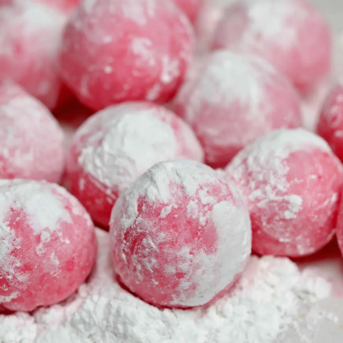 Shaping homemade watermelon mochi balls by hand.