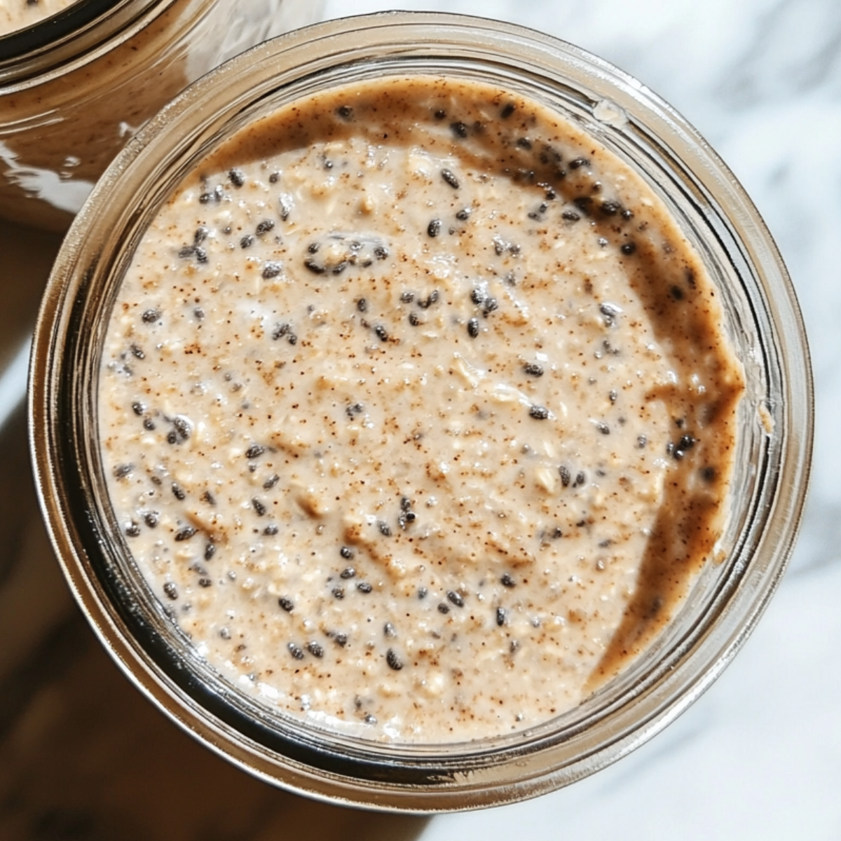 Alt Text: Jars of cinnamon roll overnight oats placed on, ready to chill in the fridge