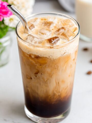 Homemade shaken brown sugar espresso served in a clear glass over ice, seen from above on a kitchen counter