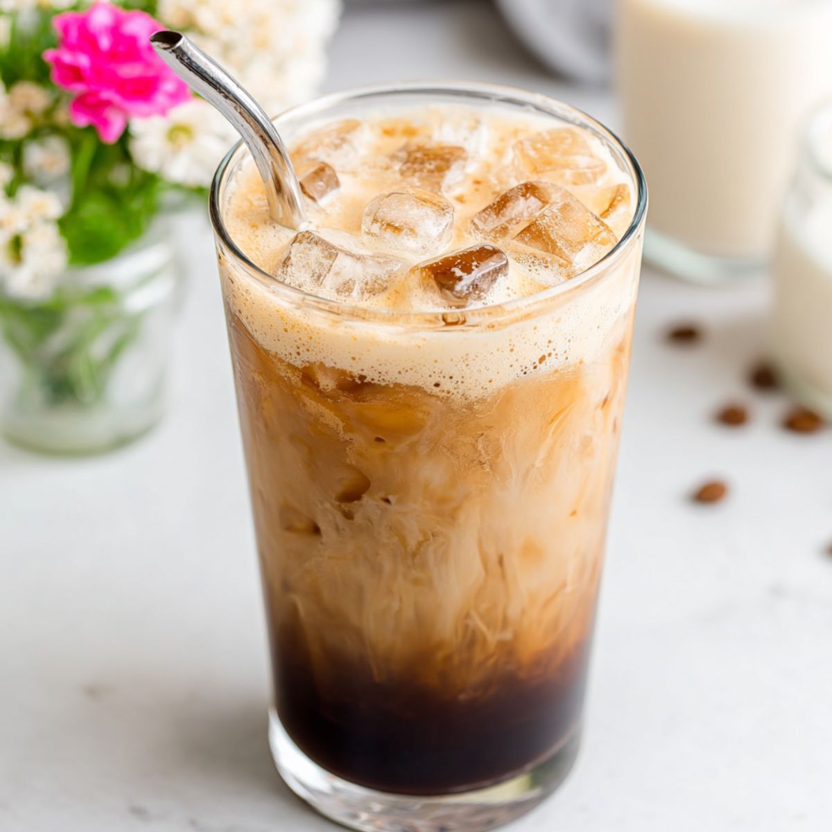 Homemade shaken brown sugar espresso served in a clear glass over ice, seen from above on a kitchen counter