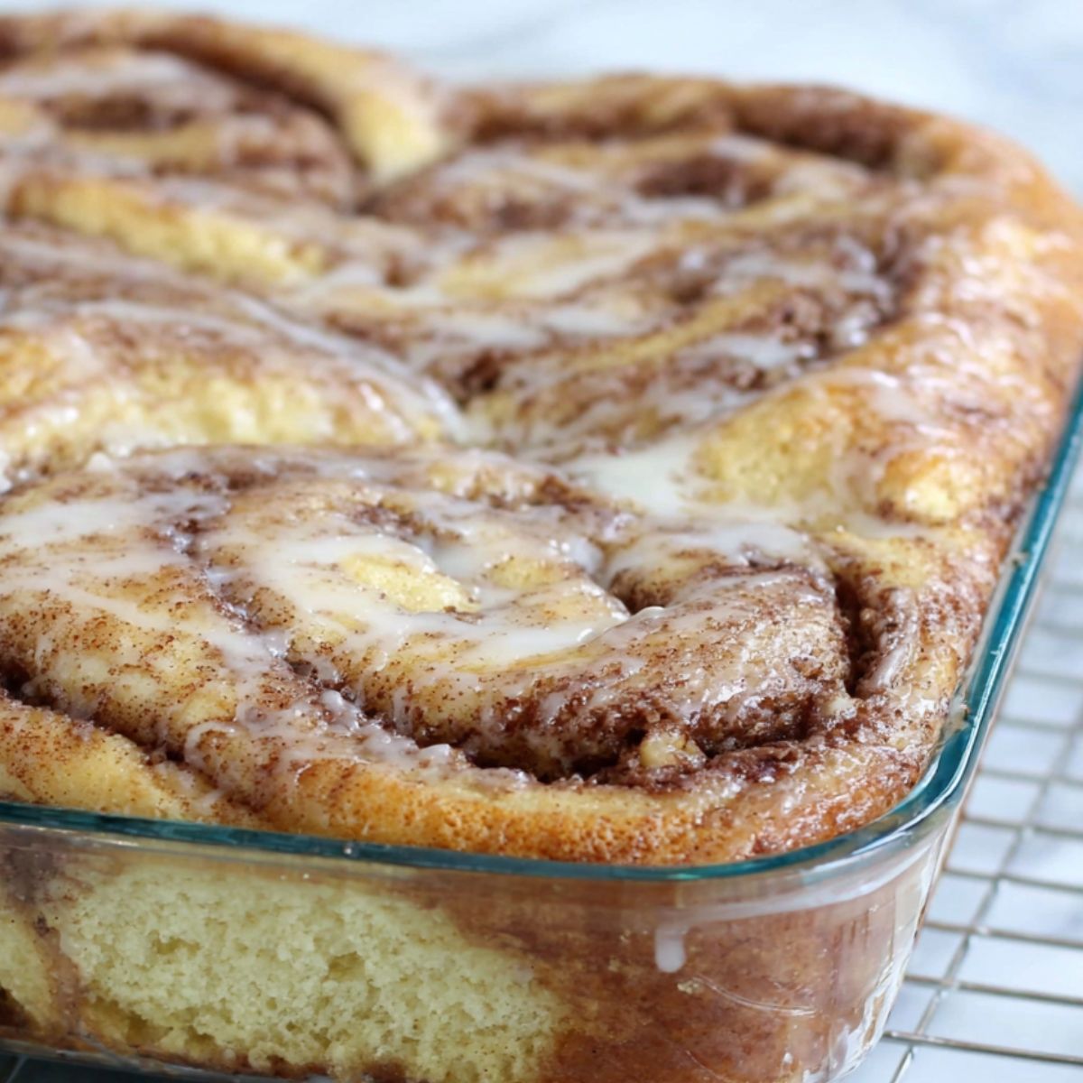 Baked cinnamon roll cake coming out of the oven