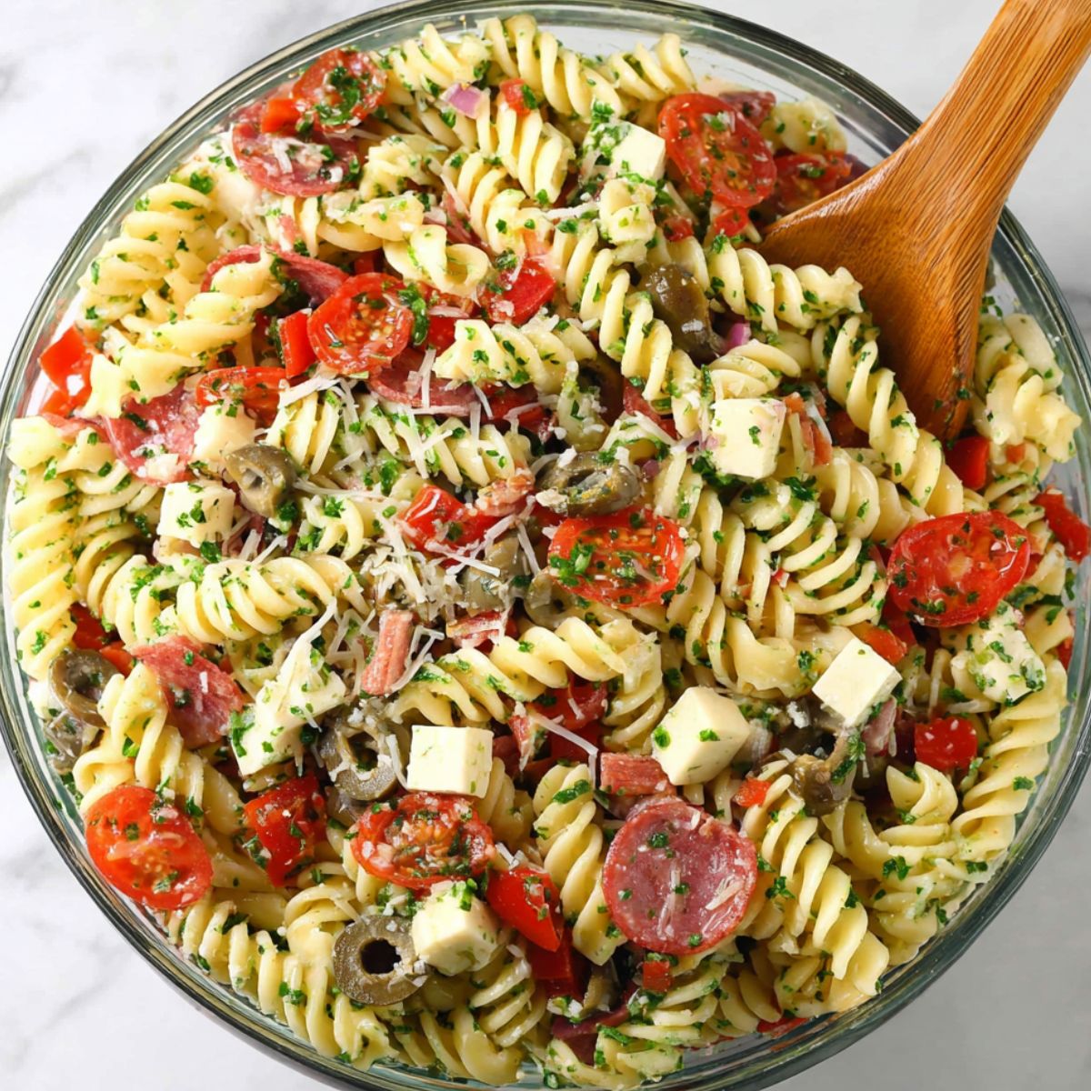 Mixing the finished pizza pasta salad in a large bowl