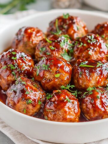 Homemade BBQ meatballs glazed with sticky barbecue sauce on a white plate