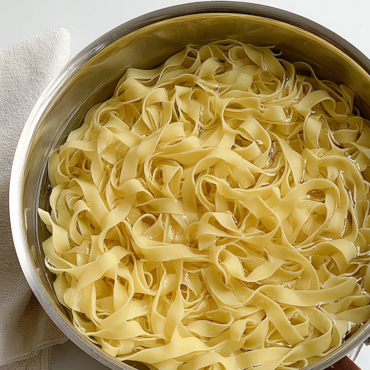 Gluten-free noodles boiling in a pot on a kitchen counter