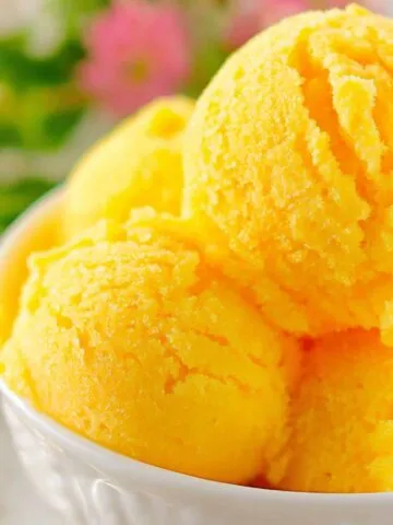 A bowl of homemade mango sorbet ice cream on a white kitchen counter