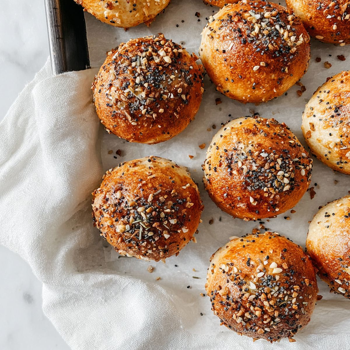 Baked Bagel Bites on a tray with everything seasoning and napkin edge