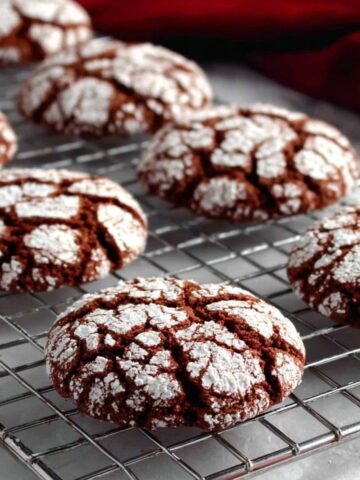 Gluten free crinkle cookies with crackled tops on a wire rack