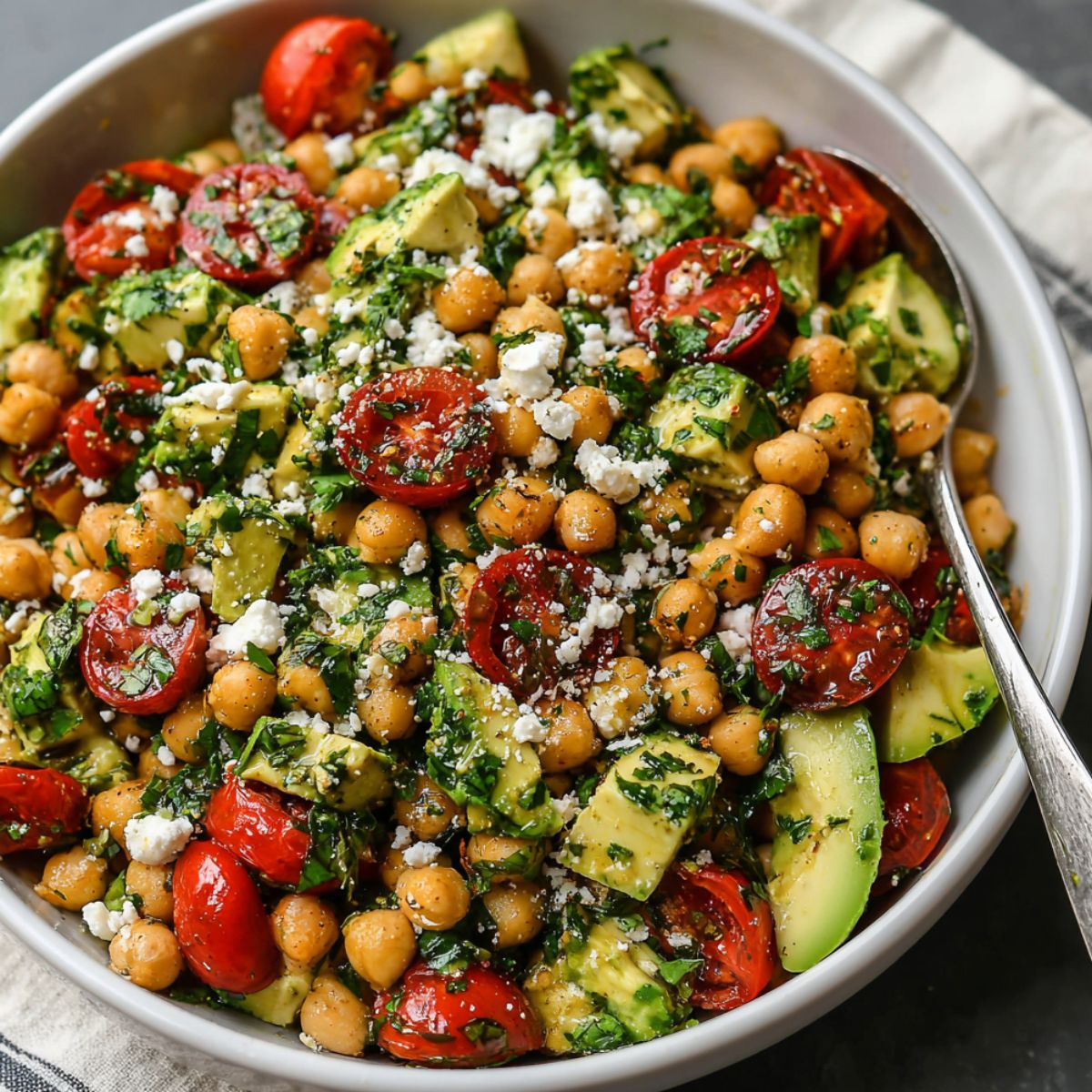 Chickpea Feta Avocado Salad served in a white bowl on a kitchen counter