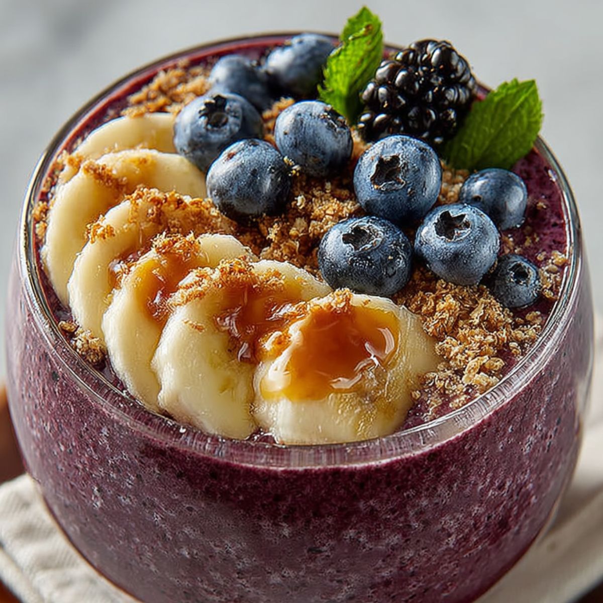 Alt Text: Best acai bowl topped with fresh fruit and granola on a white kitchen counter