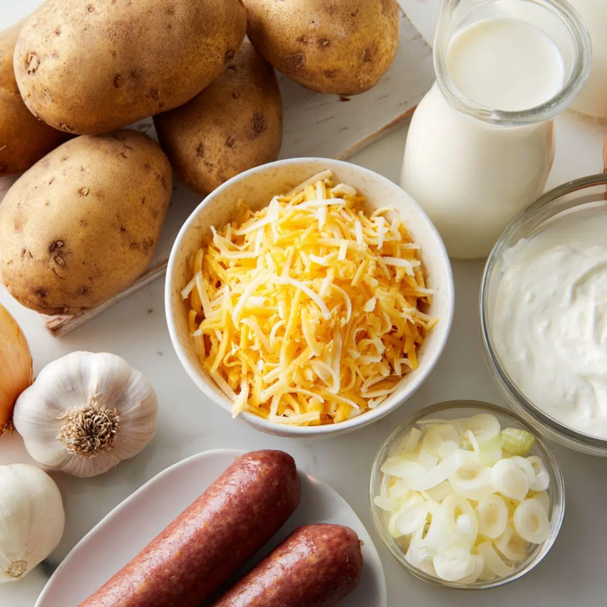 Ingredients for cheesy ranch potatoes and smoked sausage laid out on a kitchen counter