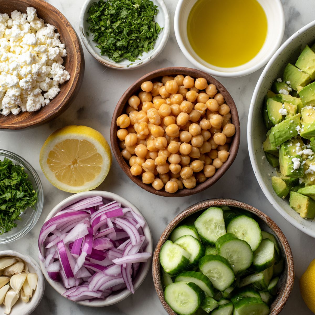 Raw ingredients for Chickpea Feta Avocado Salad on a kitchen counter