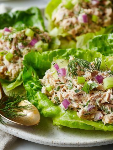 Freshly made keto tuna salad served in with lettuce leaves on white plate