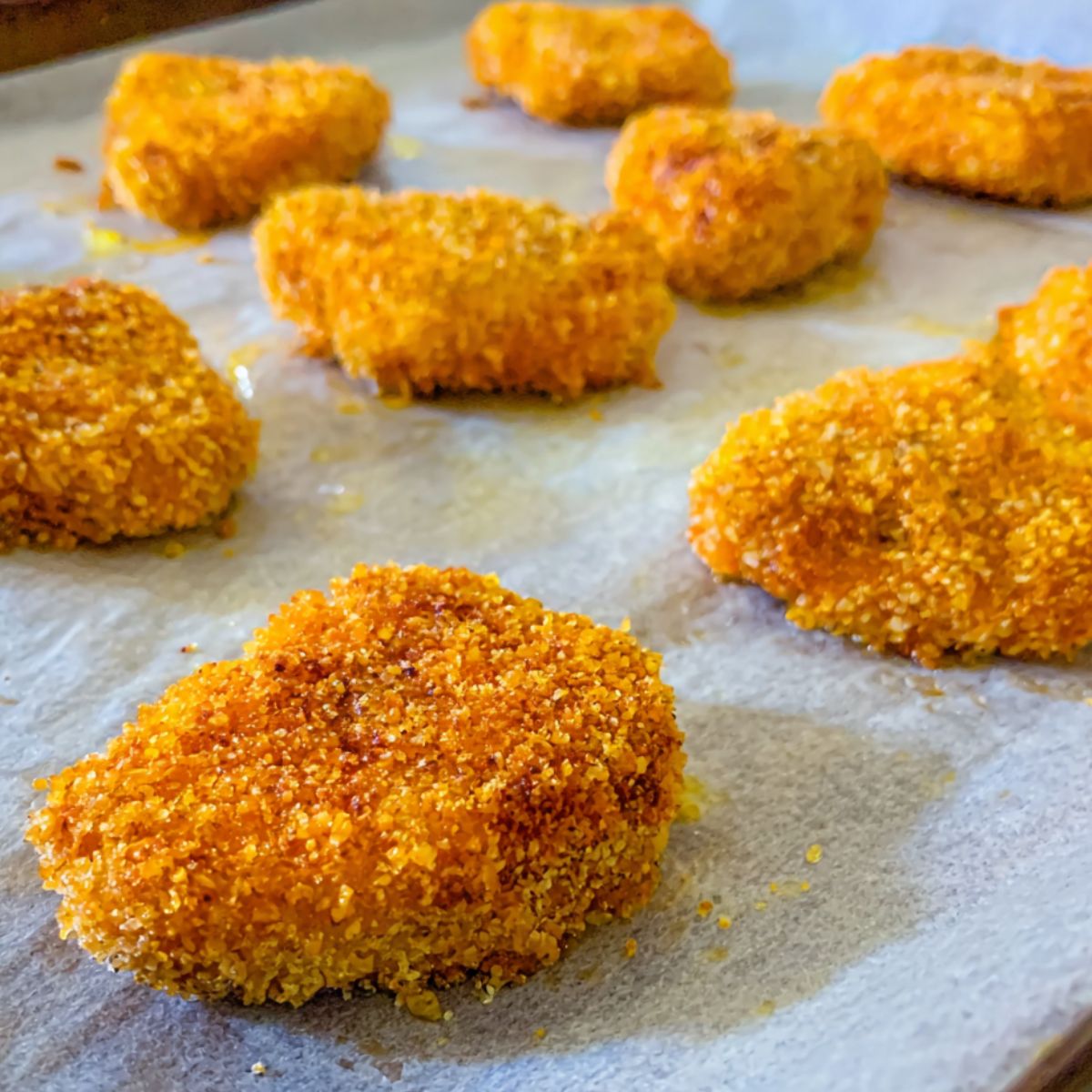 Baked ground chicken nuggets on a tray, golden and crispy.