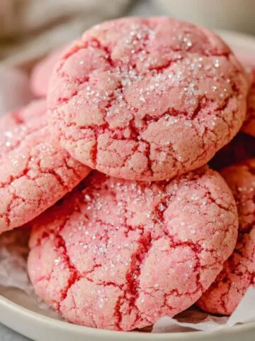 Overhead view of a batch of homemade pink cookies on parchment paper
