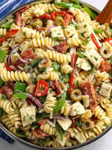 Homemade pizza pasta salad recipe served in a bowl on a kitchen counter