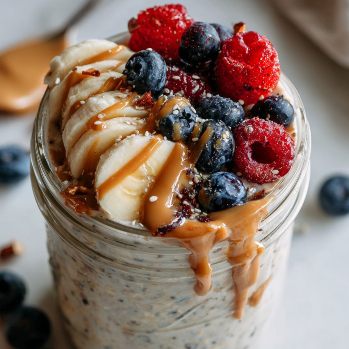 Homemade protein overnight oats in a mason jar with toppings on a white kitchen counter.