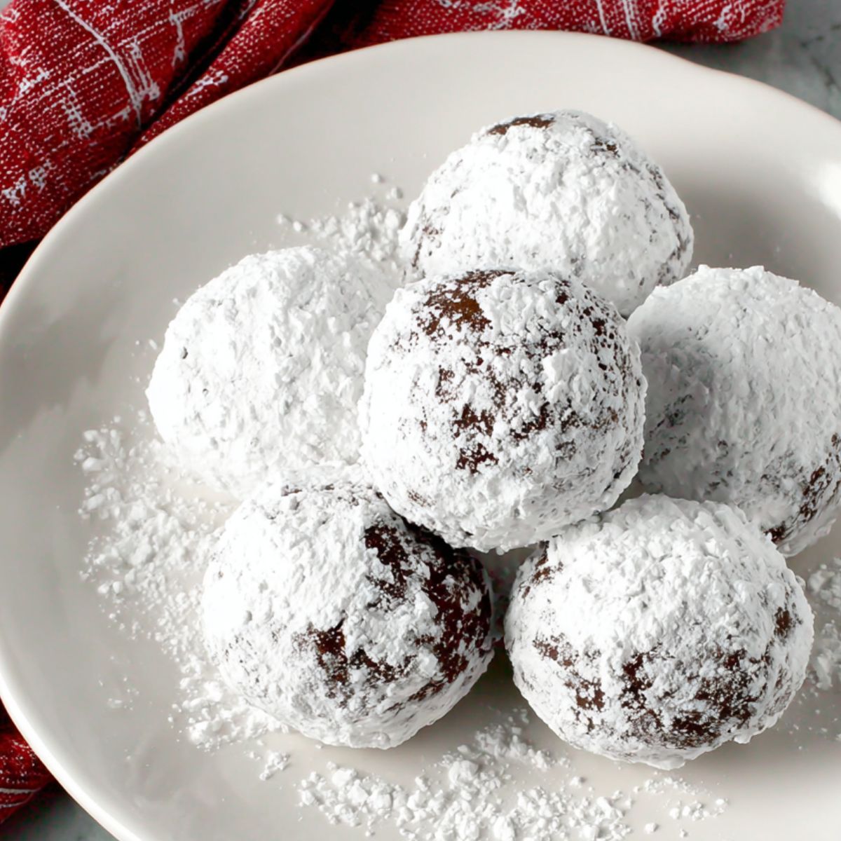 Rolling gluten free cookie dough balls in powdered sugar