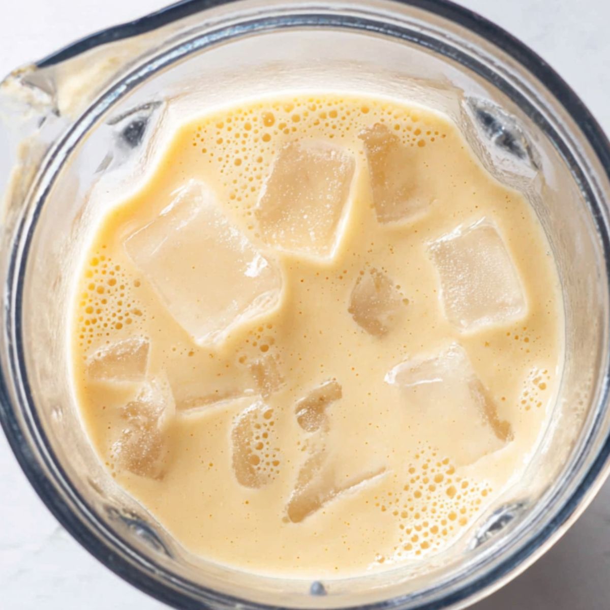 Blended smoothie with added ice and spoon for texture check