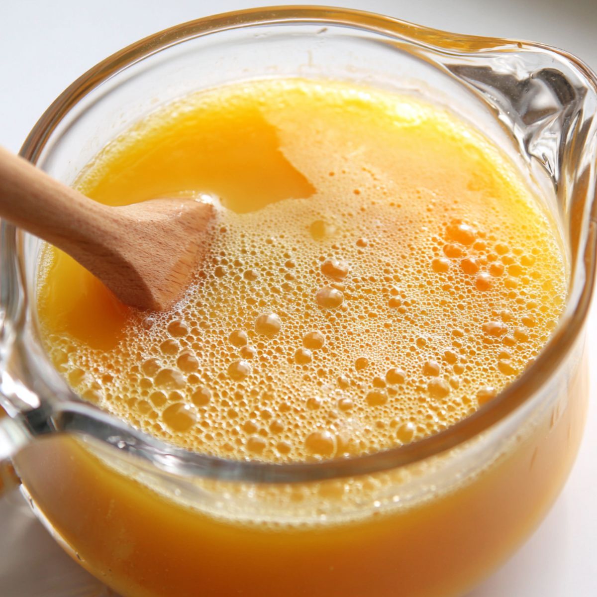 Stirring peach puree and lemon juice in a pitcher