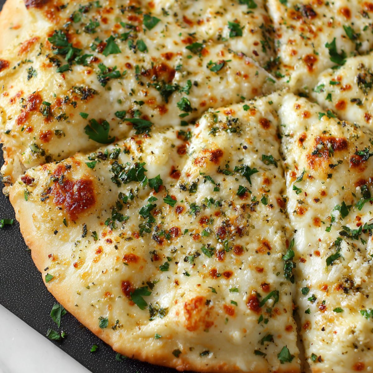 Cheesy garlic pizza just out of the oven with golden edges and bubbling cheese
