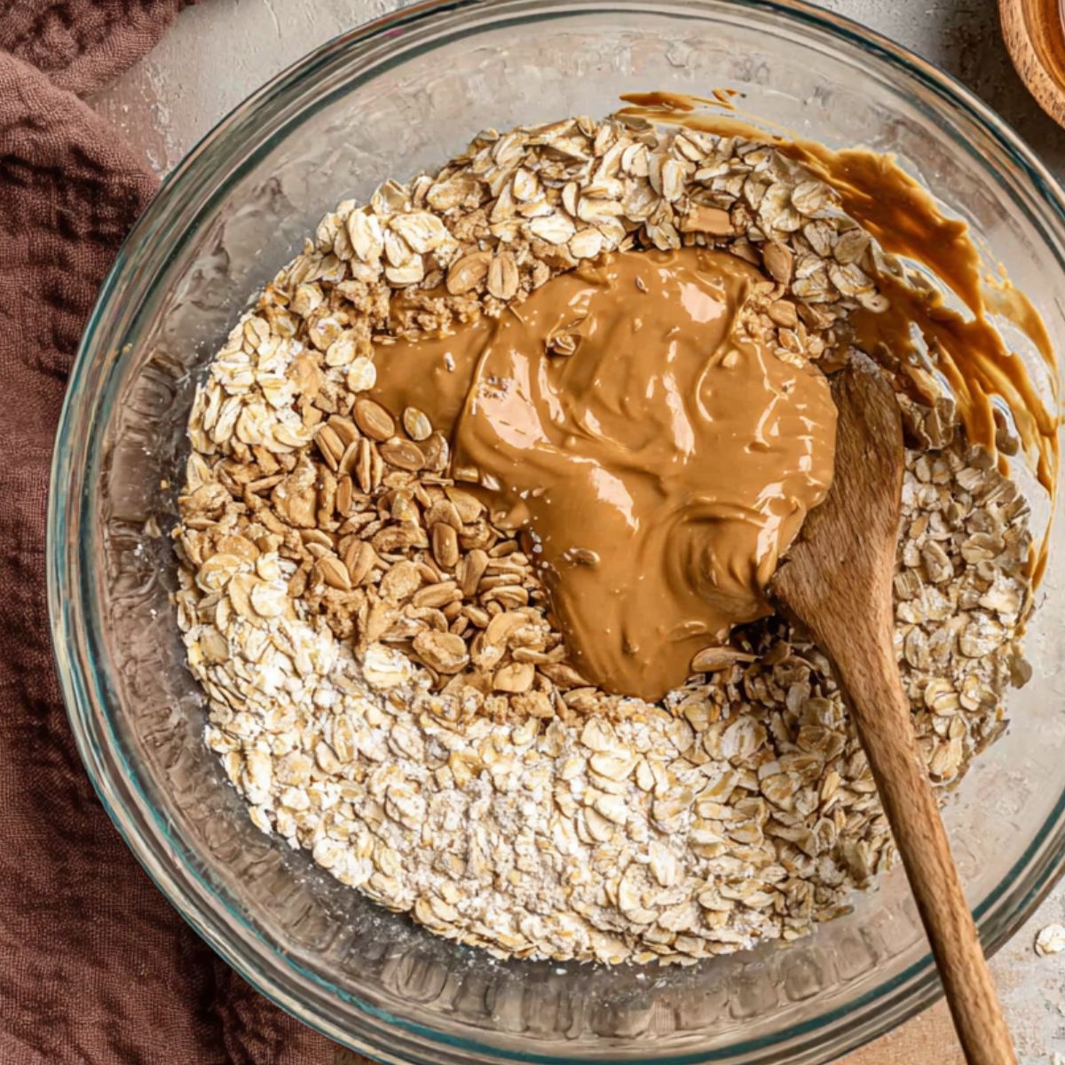 Mixing oats, peanut butter, and honey in a bowl for protein balls.