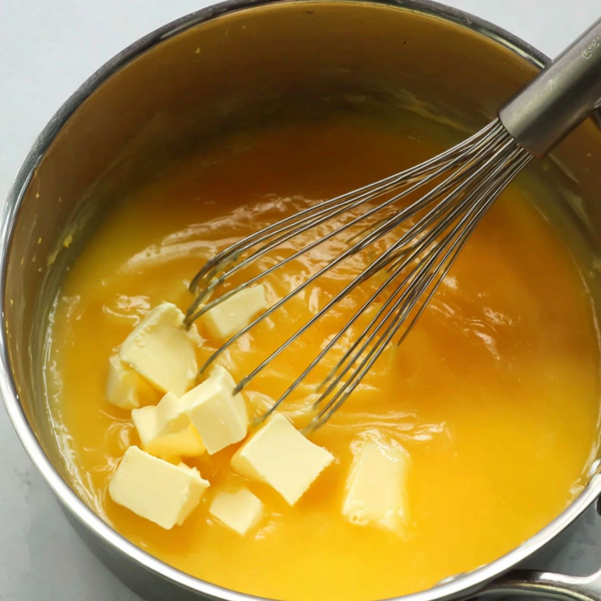 Whisking cold butter into lemon curd for a smooth finish