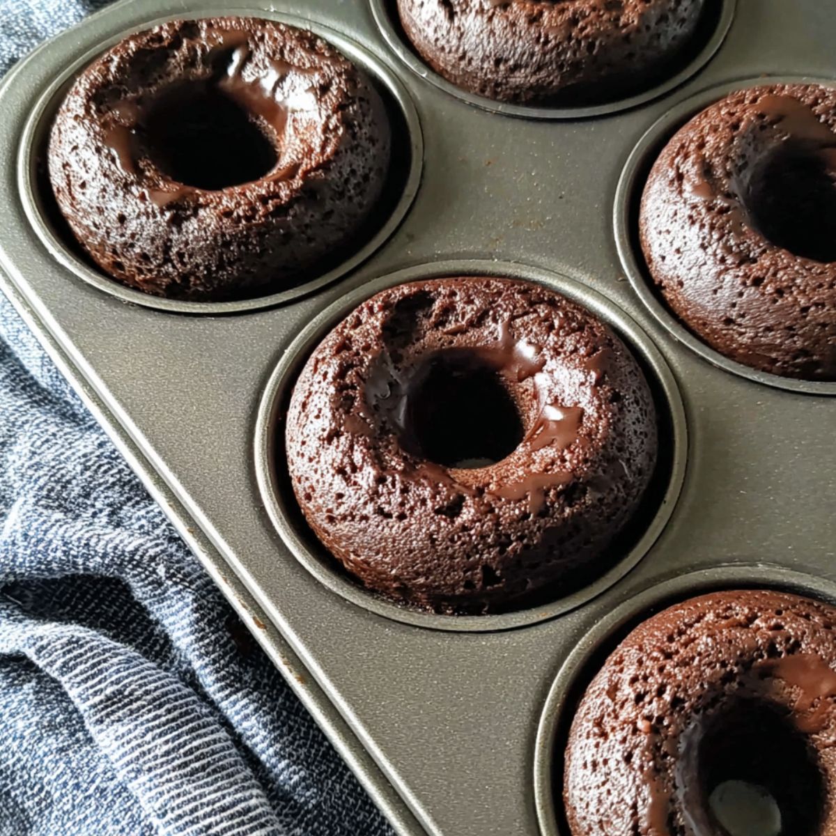 Freshly baked Chocolate protein donuts resting in a donuts pan.